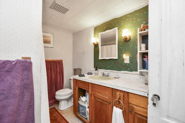 bathroom with tile patterned flooring, vanity, and toilet