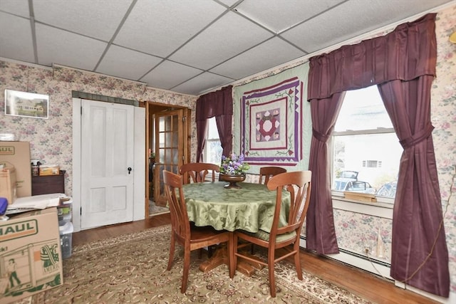 dining space featuring hardwood / wood-style flooring and a paneled ceiling