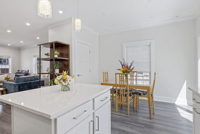 kitchen featuring baseboards, ornamental molding, white cabinetry, and wood finished floors