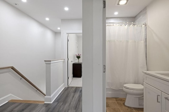 bathroom with vanity, recessed lighting, wood finished floors, and toilet