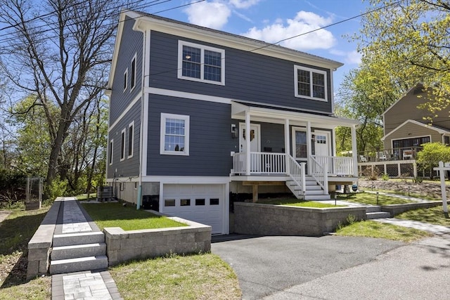 view of front facade with a porch, a garage, and driveway
