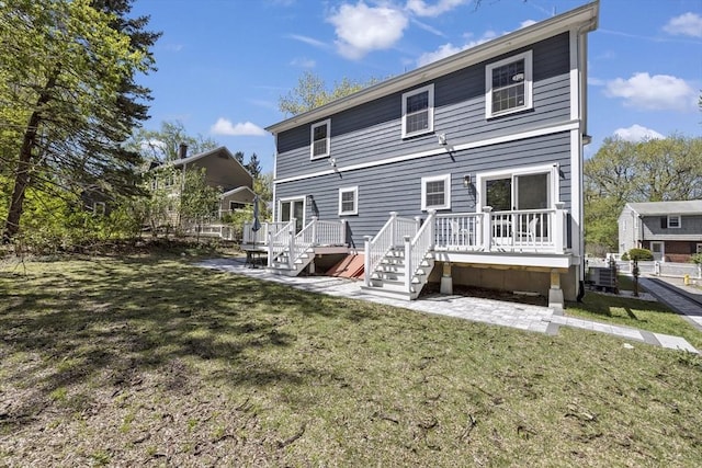 rear view of property featuring central air condition unit, a wooden deck, stairway, a lawn, and a patio