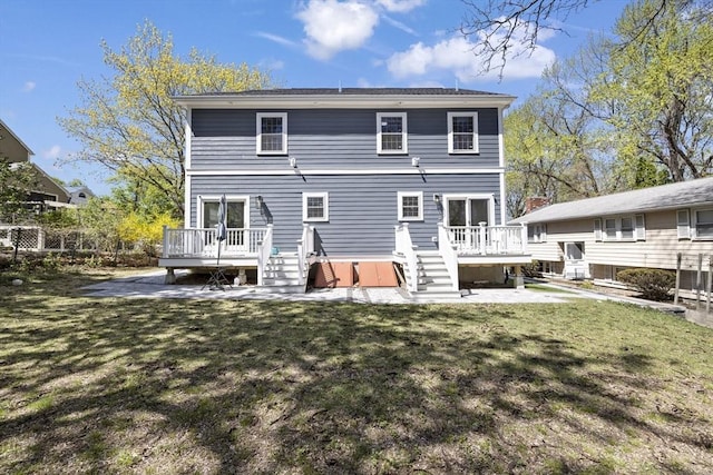 rear view of house with a wooden deck and a yard
