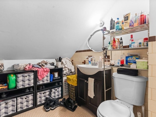 bathroom with vanity, tile patterned flooring, toilet, and lofted ceiling