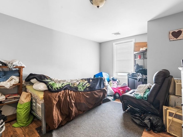 bedroom featuring wood finished floors and visible vents