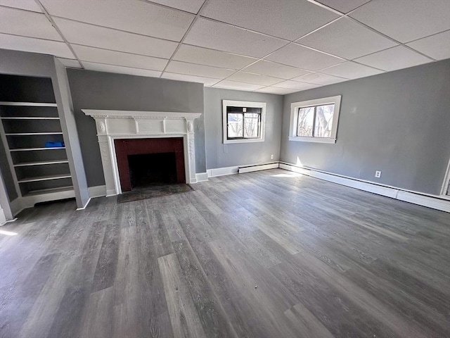 128 Mill St, Springfield, MA 01108 - unfurnished living room featuring a fireplace with flush hearth, dark wood finished floors, a drop ceiling, and baseboards
