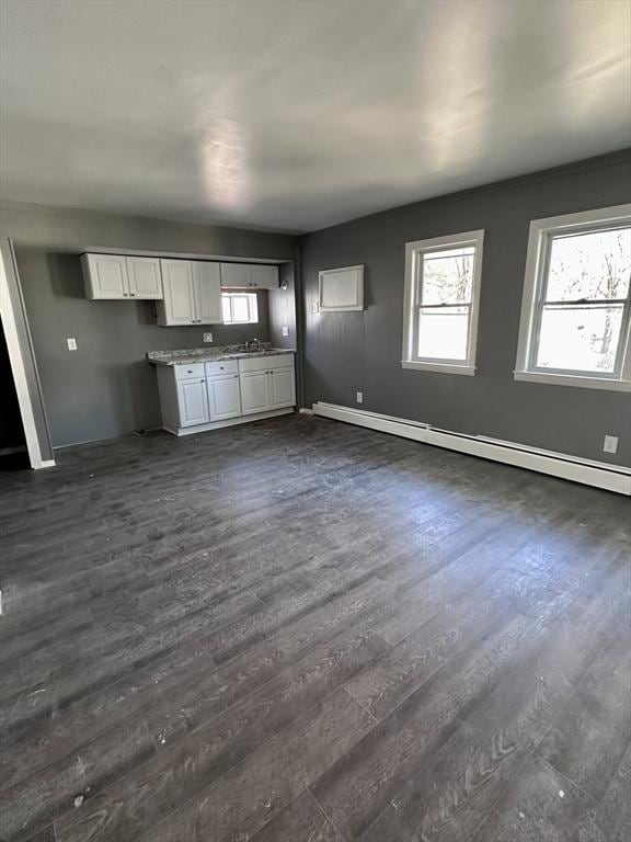 128 Mill St, Springfield, MA 01108 - unfurnished living room with a sink, baseboards, a baseboard heating unit, and dark wood-type flooring