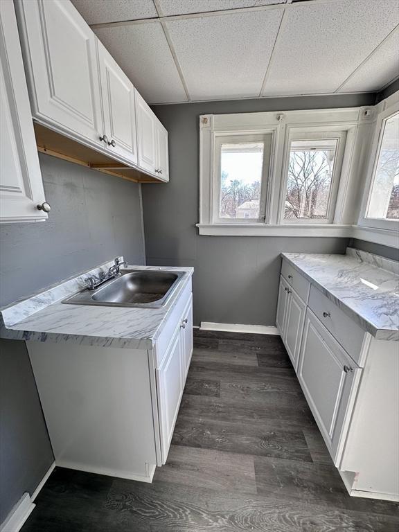 128 Mill St, Springfield, MA 01108 - clothes washing area featuring baseboards, a sink, and dark wood-style flooring