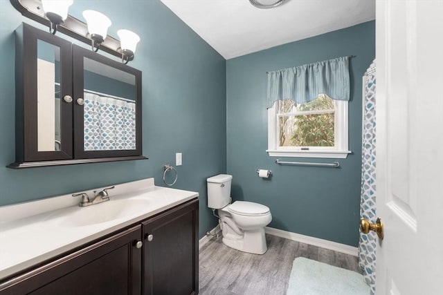 bathroom with toilet, hardwood / wood-style floors, and vanity