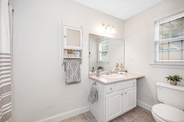 bathroom with toilet, vanity, and tile patterned floors