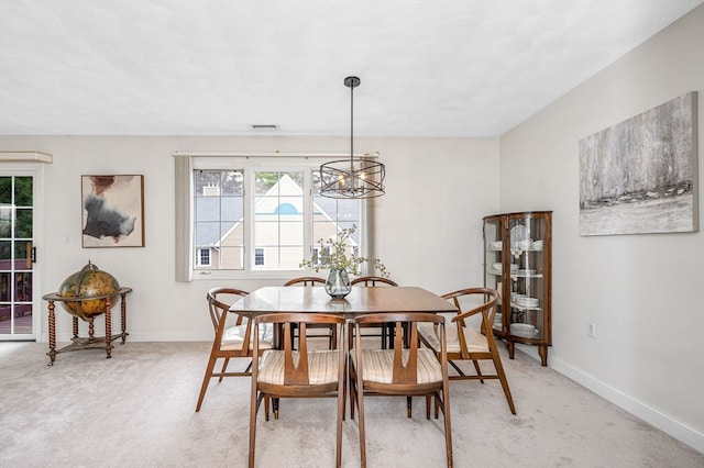 carpeted dining room featuring a chandelier