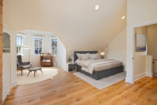124 Boston Ave, Medford, MA 02155 - bedroom featuring light wood-style flooring, lofted ceiling, baseboards, and arched walkways