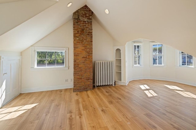 124 Boston Ave, Medford, MA 02155 - bonus room featuring radiator heating unit, vaulted ceiling, light wood-style flooring, baseboards, and arched walkways