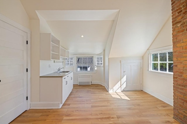 124 Boston Ave, Medford, MA 02155 - kitchen featuring a sink, open shelves, light wood-style floors, white cabinetry, and baseboards