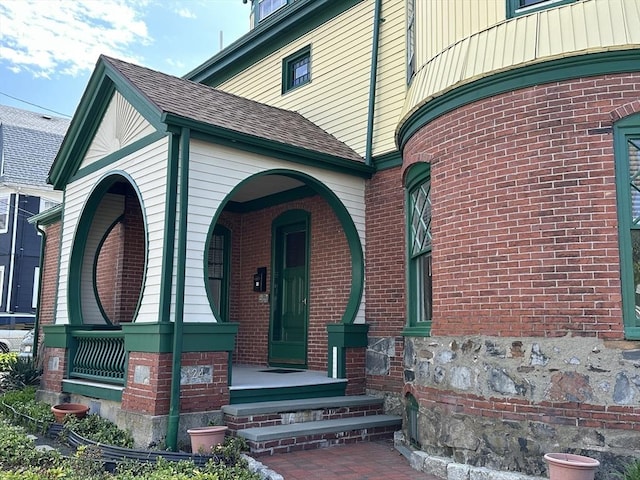 124 Boston Ave, Medford, MA 02155 - property entrance featuring brick siding, covered porch, and a shingled roof