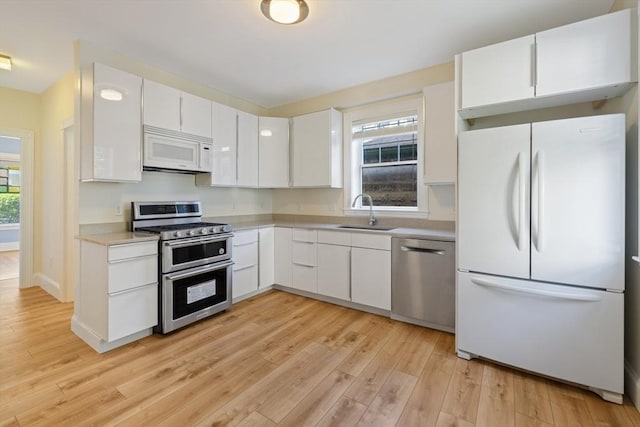 124 Boston Ave, Medford, MA 02155 - kitchen with stainless steel appliances, a sink, light wood-style flooring, and light countertops