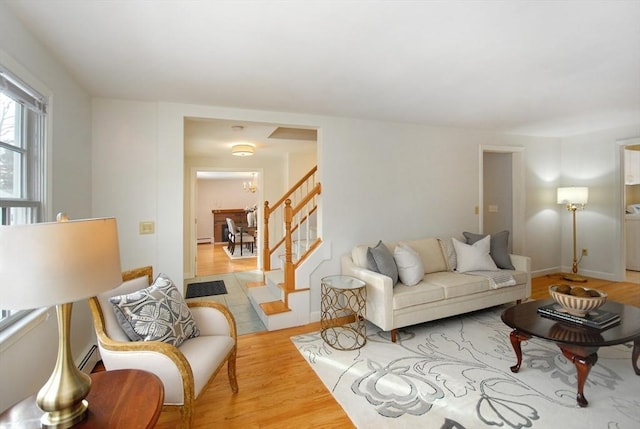 living area with stairs and wood finished floors