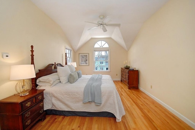 bedroom with light wood-type flooring, lofted ceiling, baseboards, and ceiling fan