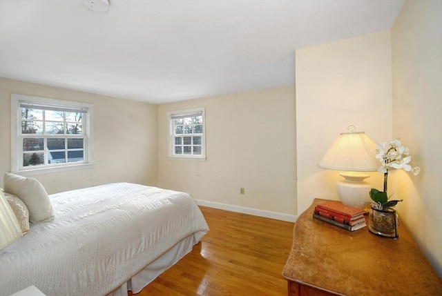 bedroom featuring baseboards and wood finished floors