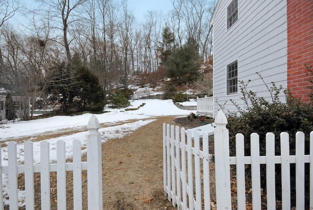 yard covered in snow with a fenced front yard