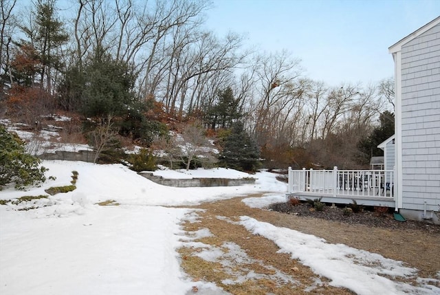 yard covered in snow with a wooden deck