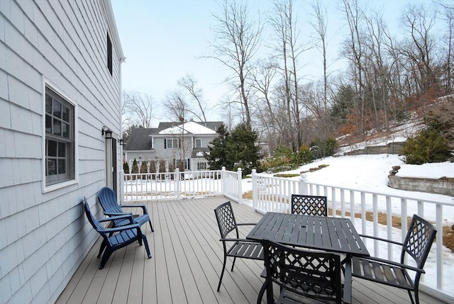 snow covered deck featuring outdoor dining area