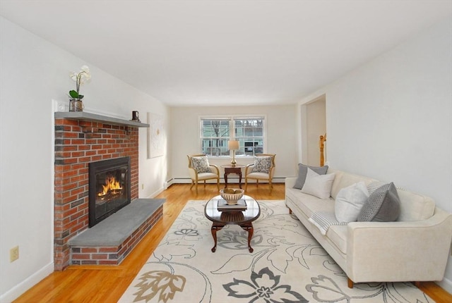 living room featuring a fireplace, wood finished floors, baseboards, and a baseboard heating unit