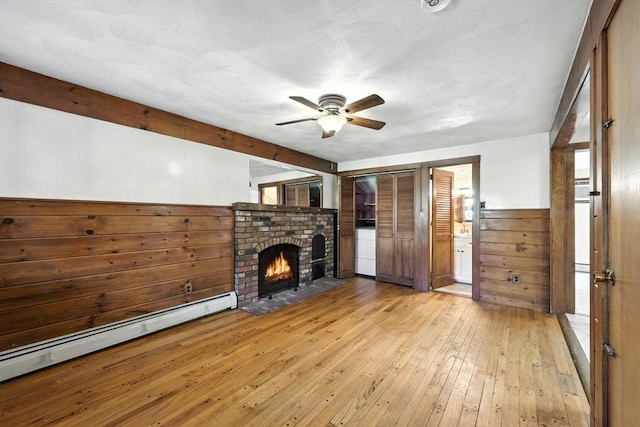 51 Glenview Dr, West Springfield, MA 01089 - unfurnished living room featuring baseboard heating, a ceiling fan, hardwood / wood-style floors, a brick fireplace, and wainscoting