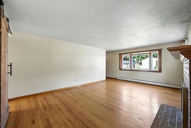 51 Glenview Dr, West Springfield, MA 01089 - unfurnished living room with a baseboard heating unit, wood finished floors, a textured ceiling, a large fireplace, and a barn door