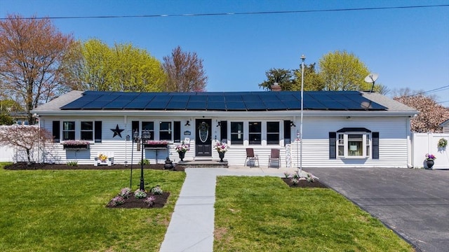 31 Darling St, Acushnet, MA 02743 - ranch-style house featuring roof mounted solar panels, fence, a chimney, and a front lawn