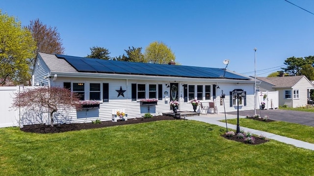 31 Darling St, Acushnet, MA 02743 - single story home with roof mounted solar panels, fence, and a front yard