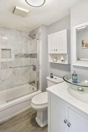 bathroom featuring toilet, bathtub / shower combination, wood finished floors, and vanity