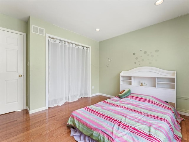 bedroom with recessed lighting, wood finished floors, visible vents, and baseboards