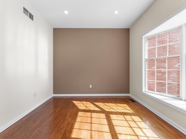 spare room featuring recessed lighting, visible vents, baseboards, and wood finished floors