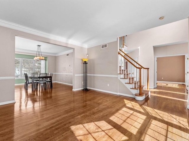 interior space featuring wood finished floors, visible vents, baseboards, and stairs