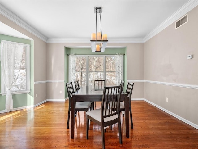 dining area with plenty of natural light, wood finished floors, and visible vents