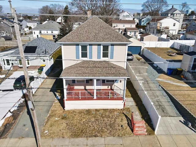 view of front of property featuring roof with shingles, a fenced backyard, and a residential view