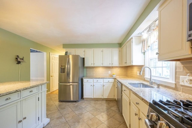 165 Roundtop Rd, Marlborough, MA 01752 - kitchen featuring appliances with stainless steel finishes, a sink, tasteful backsplash, and light stone countertops