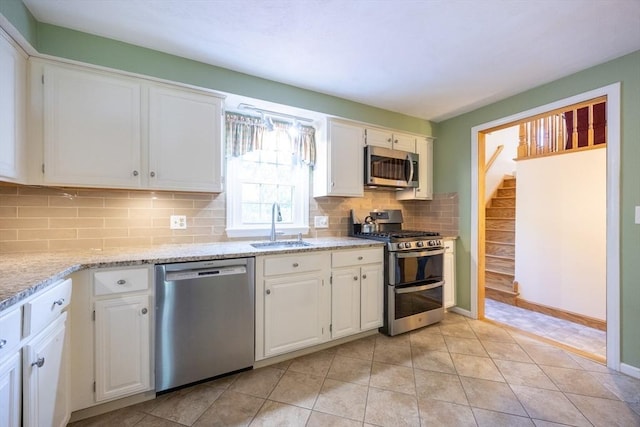 165 Roundtop Rd, Marlborough, MA 01752 - kitchen featuring appliances with stainless steel finishes, a sink, white cabinetry, tasteful backsplash, and light stone counters