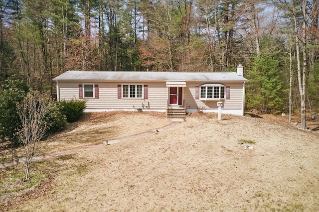 58 Daniel Shays Hwy, Pelham, MA 01007 - manufactured / mobile home featuring a view of trees and a chimney