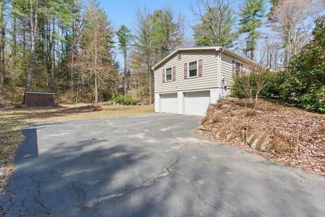 58 Daniel Shays Hwy, Pelham, MA 01007 - view of property exterior with an attached garage and aphalt driveway