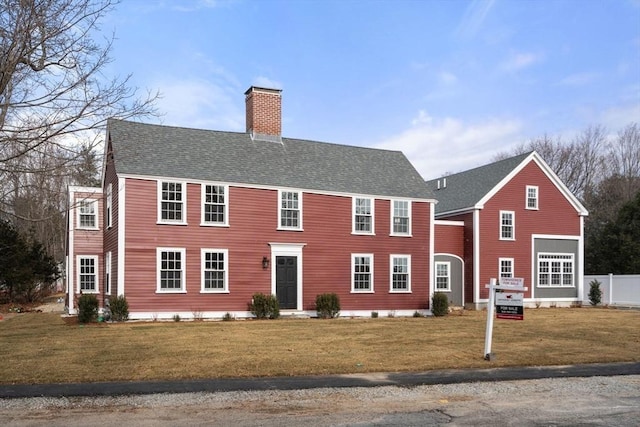 colonial house featuring a front lawn