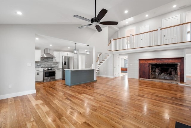 unfurnished living room featuring high vaulted ceiling, ceiling fan, and light hardwood / wood-style flooring