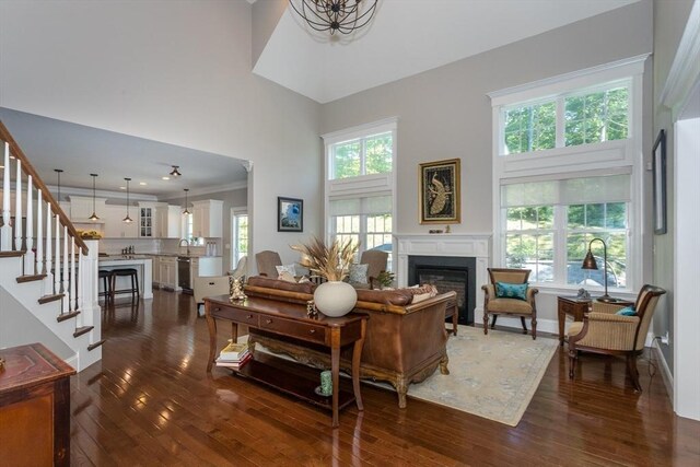 1 Clearview Dr, Franklin, MA 02038 - living area with a high ceiling, a glass covered fireplace, dark wood-style flooring, stairs, and crown molding