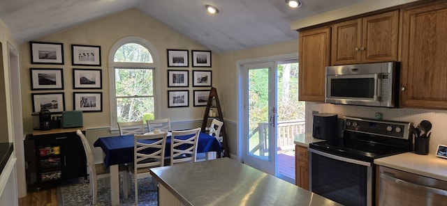 kitchen with decorative backsplash, dark hardwood / wood-style flooring, stainless steel appliances, and vaulted ceiling