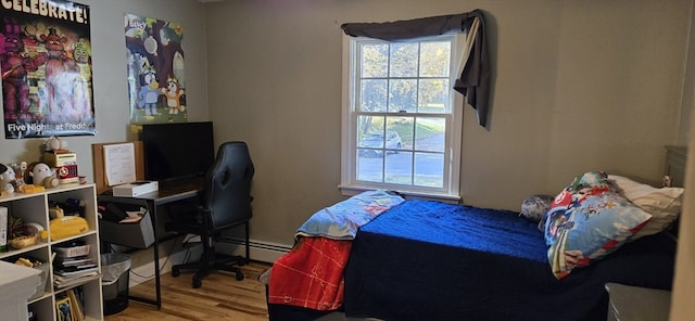 bedroom with hardwood / wood-style flooring and a baseboard radiator