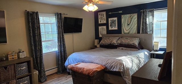 bedroom with ceiling fan, a baseboard radiator, and light hardwood / wood-style floors