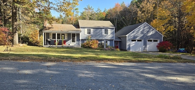 view of front of property featuring a garage, a porch, and a front lawn