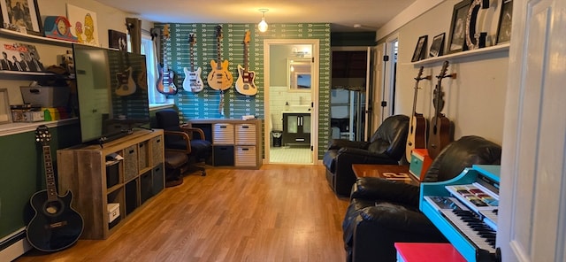 interior space with a baseboard heating unit and light hardwood / wood-style floors