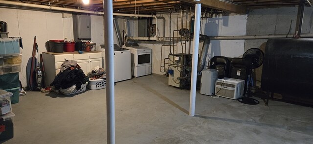 basement featuring electric panel and washing machine and clothes dryer